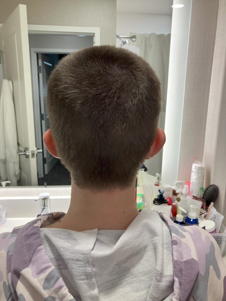 The back of a woman's buzzed head.