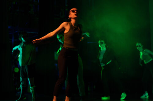 Woman dancing on stage in the spotlight, midturn.