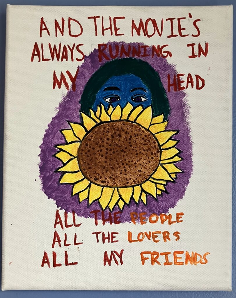 Acrylic paint on canvas of a girl's face partially hidden behind a large yellow sunflower. The girl's skin in blue and her hair in green. She is surrounded by a ring of purple light. The following song lyrics from a Conan Gray song are written in red above her head: "And the movie's always running in my head." Beneath her head are the following lyrics from the same song: "All the people, all the lovers, all my friends." The words are written in red, except the last words of each line are in orange for emphasis.