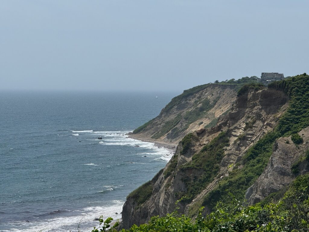 A rocky cliffside leading to the ocean.