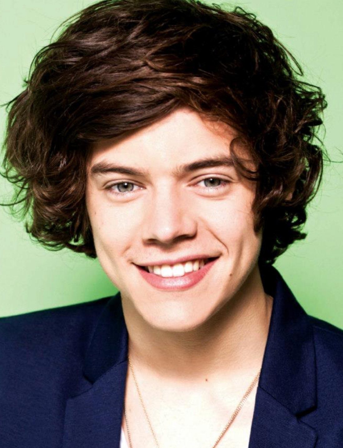 Young Harry Styles from his early days in the band One Direction with a big, side-swept haircut.