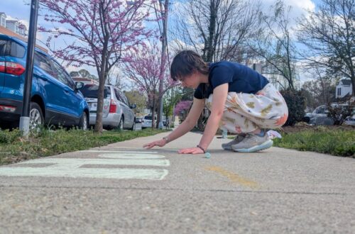 Lexi chalking in front of the CCM to advertise for Holy Week events.